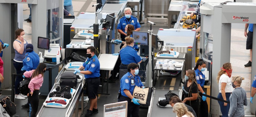 Transportation Security Administration agents process passengers at the south security checkpoint in Denver International Airport on June 10.
