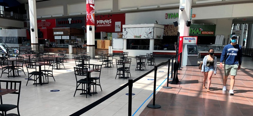 People walk past the nearly empty food court at Providence Place shopping mall, Monday, June 1 in Rhode Island.