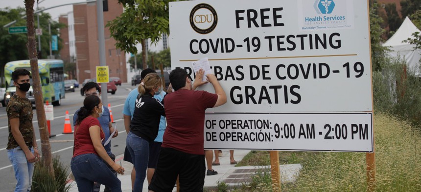 People fill out forms at a mobile coronavirus testing site at the Charles Drew University of Medicine and Science in Los Angeles on Wednesday. 