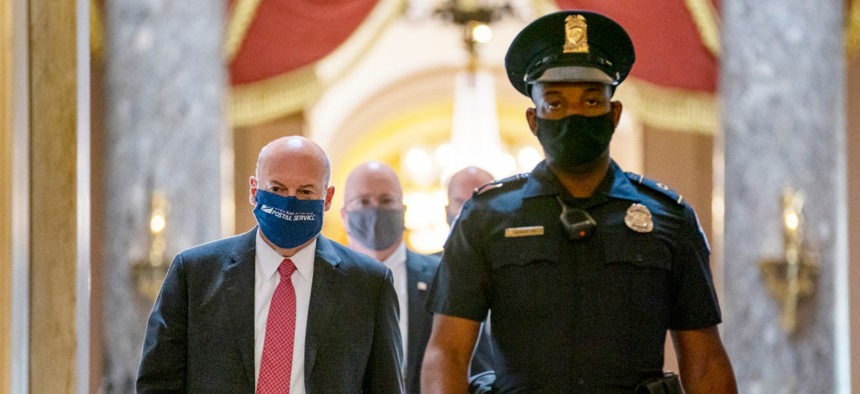 Postmaster General Louis DeJoy, left, is escorted to House Speaker Nancy Pelosi's office on Capitol Hill in Washington, Wednesday, Aug. 5, 2020. 