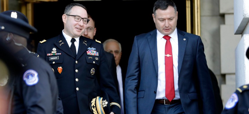 Then-National Security Council aide Lt. Col. Alexander Vindman, left, walks with his twin brother, Army Lt. Col. Yevgeny Vindman, after testifying before the House Intelligence Committee in November 2019.