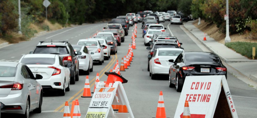 Motorists at a COVID-19 testing site at Dodger Stadium in Los Angeles in June. Amid soaring demand and a nationwide shortage of testing, the CDC issued controversial guidance on who should get tested.