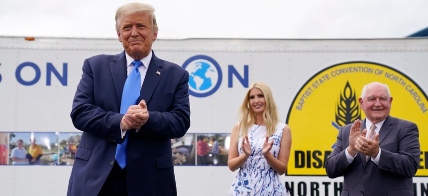 President Donald Trump arrives to deliver remarks on the "Farmers to Families Food Box Program" at Flavor First Growers and Packers, Monday, Aug. 24, in Mills River, N.C. Ivanka Trump, center and Agriculture Secretary Sonny Perdue, right, applaud.