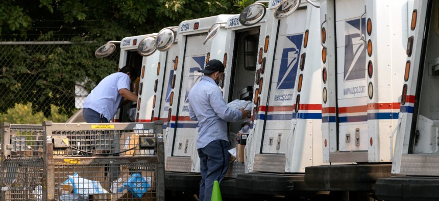 Postal workers load their mail delivery vehicles at the Panorama city post office on Thursday, Aug. 20, 2020 in the Panorama City section of Los Angeles.