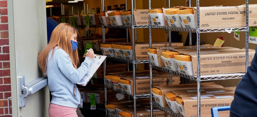 A worker logs boxes containing mail-in ballots, part of the first batch of 111,000 mail-in ballots, as they are shipped from the Douglas County Election Commission's office to the post office, in Omaha, Neb., on Sept. 28. 