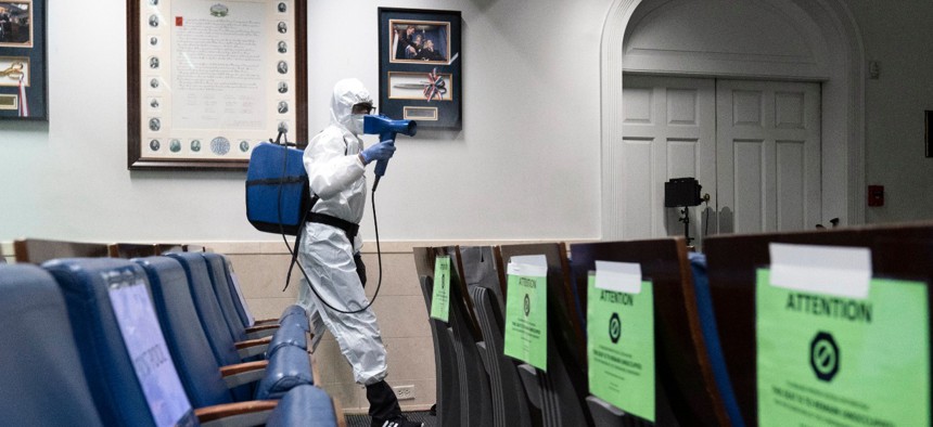 A member of the cleaning staff sprays the James Brady Briefing Room of the White House on Monday. 