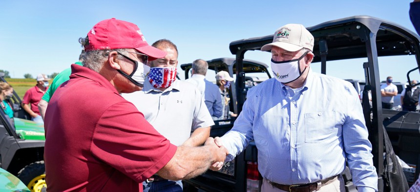 Agriculture Secretary Sonny Perdue, right, greets farmer Jim Greif, left, during a stop at the Heath Stolee farm, Thursday, Sept. 3, 2020, in Radcliffe, Iowa.