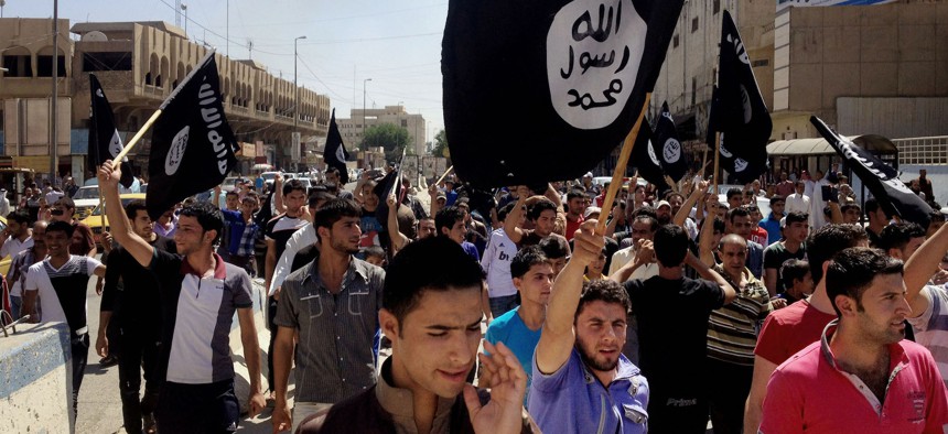 Demonstrators chant pro-Islamic State group, slogans as they carry the group's flags in front of the provincial government headquarters in Mosul in 2014.