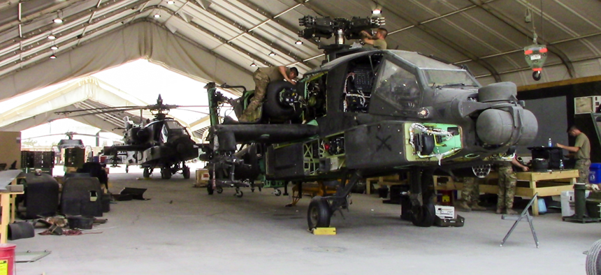 Soldiers work on an AH-64E Apache at Camp Taji Military Complex, Iraq, in July 2017. 