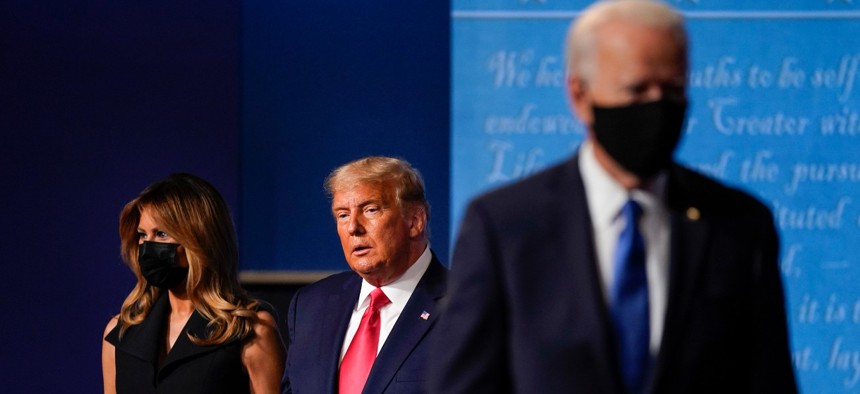 First Lady Melania Trump, left, and President Trump, center, remain on stage as Democratic presidential candidate former Vice President Joe Biden, right, walks away at the conclusion of the second and final presidential debate on Oct. 22. 