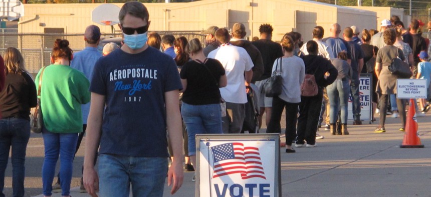 A man leaves the polling place where about 100 mostly masked northern Nevadans were waiting to vote in person at Reed High School in Sparks about two hours before the polls closed Tuesday.