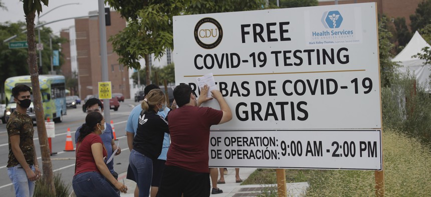 People fill out forms at a mobile testing site at the Charles Drew University of Medicine and Science during the coronavirus outbreak in Los Angeles in July.