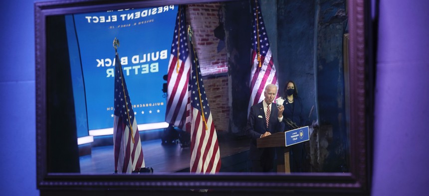 President-elect Joe Biden, accompanied by Vice President-elect Kamala Harris, shown reflected in a mirror, speaks in Delaware on Monday.