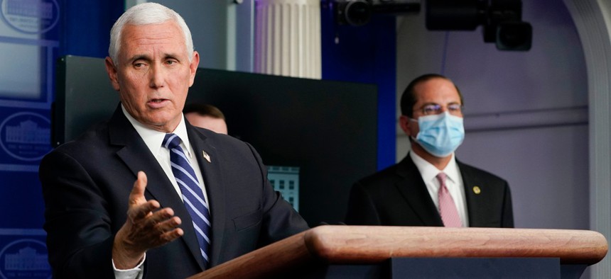 Health and Human Services Secretary Alex Azar, right, listens as Vice President Mike Pence speaks during a news conference with the coronavirus task force at the White House on Thursday.