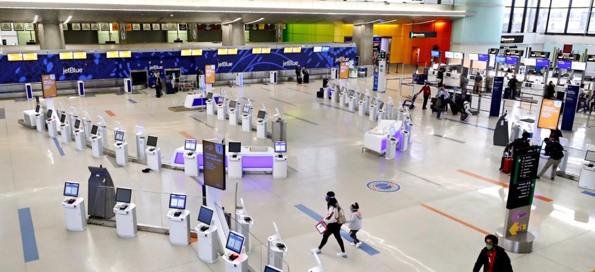 Travelers walk through the nearly empty JetBlue terminal at Logan Airport on Nov. 20 in Boston. With the coronavirus surging out of control, the nation's top public health agency pleaded with Americans not to travel for Thanksgiving. 