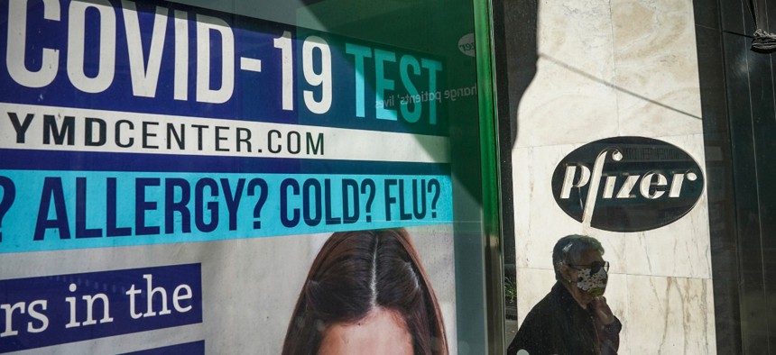A bus stop ad for COVID-19 testing is shown outside Pfizer world headquarters in New York on Nov. 9. Pfizer has one of several promising coronavirus vaccine candidates. 