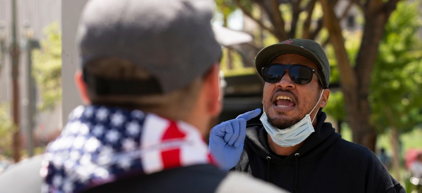 People in front of Los Angeles’ City Hall argue during a protest in May.
