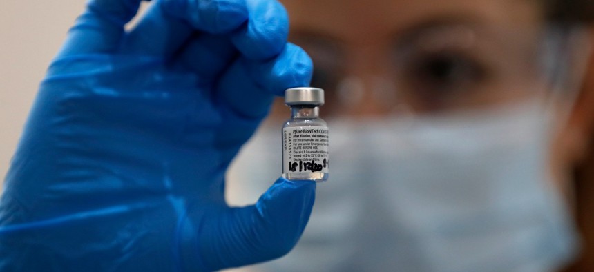 A nurse holds a vial of the Pfizer-BioNTech COVID-19 vaccine at Guy's Hospital in London on Dec. 8.