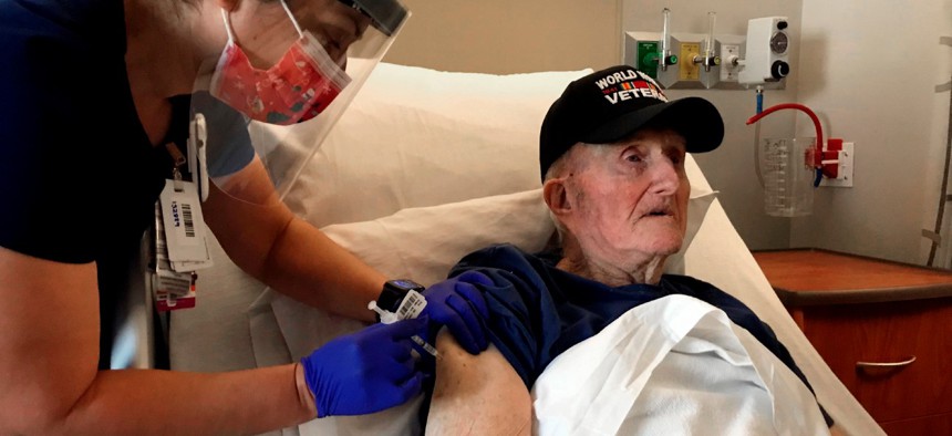 World War II veteran John Mohun, 94, receives the Pfizer-BioNTech COVID-19 vaccine at a Veterans Affairs facility in Phoenix on Tuesday.