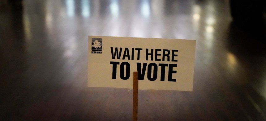 A sign is displayed for voters to guide the way at a precinct during Georgia's Senate runoff elections on Jan. 5, in Atlanta.