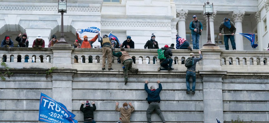 Supporters of President Donald Trump climb the west wall of the the U.S. Capitol on Wednesday, Jan. 6, 2021, in Washington. 