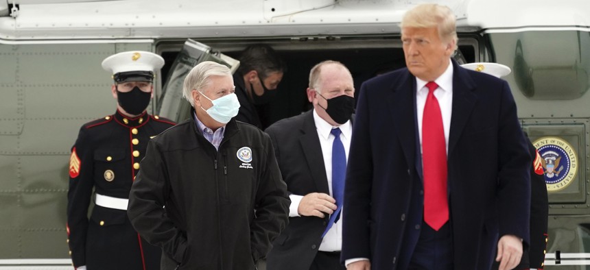 Sen. Lindsey Graham, left, walks with President Donald Trump as they board Air Force One upon arrival at Valley International Airport, Tuesday, Jan. 12, 2021, in Harlingen, Texas, after visiting a section of the border wall with Mexico 