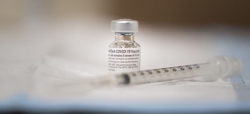 A vial of the COVID-19 vaccine is prepared to be administered at Walter Reed National Military Medical Center in December.