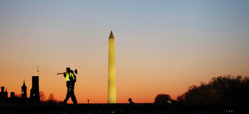 A construction worker carries a hammer on his shoulder on Wednesday at the National Mall in Washington, as a stage is prepared for Joe Biden's presidential inauguration. 
