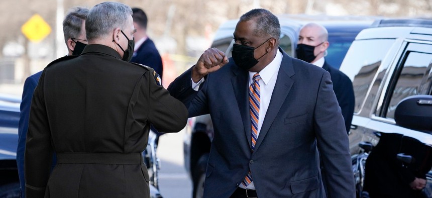 Defense Secretary Lloyd Austin, right, greets Chairman of the Joint Chiefs of Staff Mark Milley as he arrives at the Pentagon on Friday. 