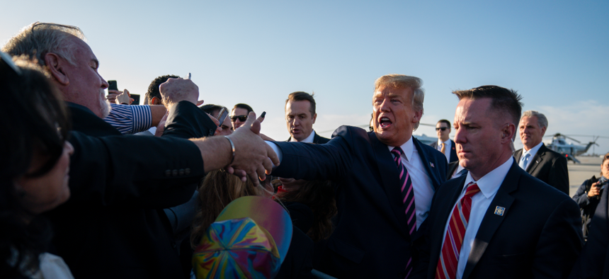 Then-President Trump greets supporters after arriving at Los Angeles International Airport in Los Angeles on February 18, 2020. Public health officials were already warning Americans about the need to prepare for the coronavirus threat.
