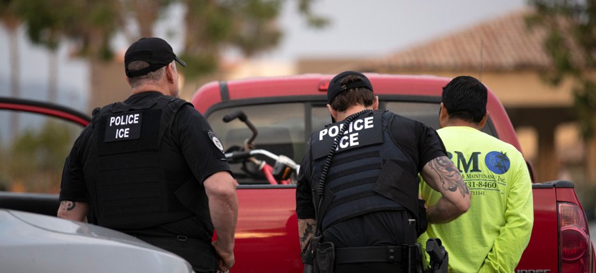 U.S. Immigration and Customs Enforcement officers detain a man during an operation in Escondido, California, in July 2019.