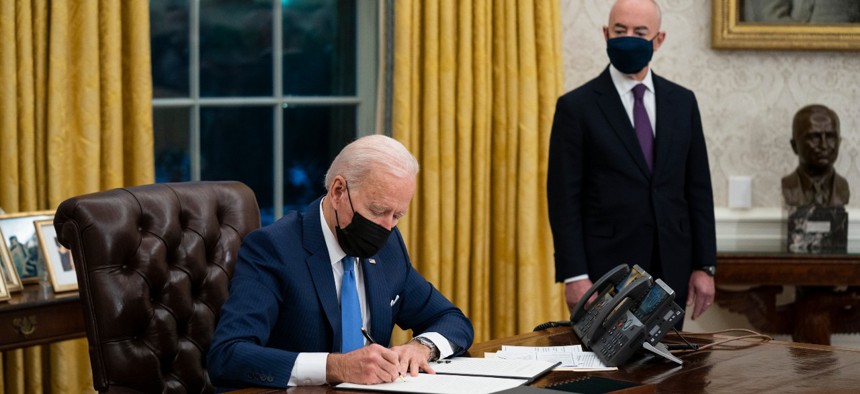 President Joe Biden talks with newly sworn in Homeland Security Secretary Alejandro Mayorkas before signing executive orders on immigration on Tuesday. 