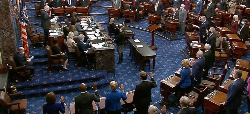 In this Jan. 26 image from video, Sen. Patrick Leahy, D-Vt., the president pro tempore of the Senate, who is presiding over the impeachment trial of former President Trump, swears in members of the Senate for the trial. 