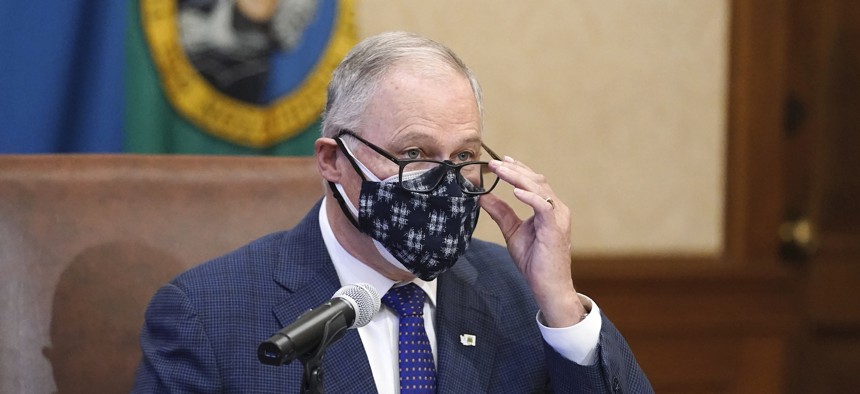 Governor Jay Inslee wears a double mask as he speaks before signing the first bill to be signed into law during the 2021 legislative session, Monday, Feb. 8, in Olympia.