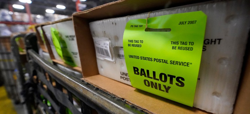 A cart holding vote-by-mail ballots is seen before being loaded into a truck for transport to a local U.S. Postal Service office on Oct. 1, 2020, at the Miami-Dade County Elections Department in Doral, Fla. 