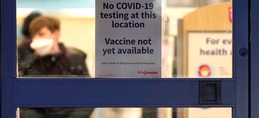 A sign saying that a COVID-19 vaccine is not yet available hangs at Walgreens in Glenview, Ill. in January