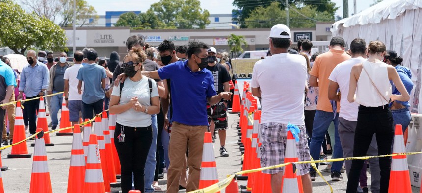 People wait in line to receive a COVID-19 vaccine at a FEMA vaccination center at Miami Dade College on Monday. Any adult in Florida is now eligible to receive the coronavirus vaccine. 
