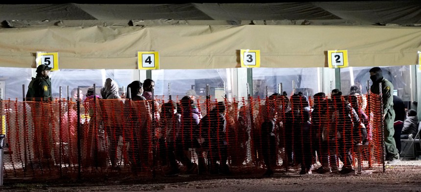 Migrants are seen in custody at a U.S. Customs and Border Protection processing area under the Anzalduas International Bridge, in Mission, Texas on March 19.