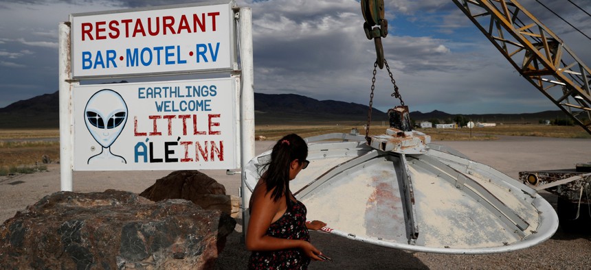 Grace Capati looks at a UFO display outside of the Little A'Le'Inn, in Rachel, Nev., the closest town to Area 51 in 2019.