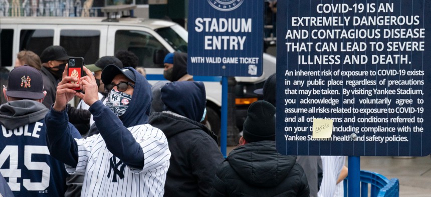 Spectators wait in a security line outside Yankee Stadium before an opening day baseball game against the Toronto Blue Jays on April 1. Schools, businesses and sports and entertainment venues are considering rapid COVID-19 tests as a requirement for entry