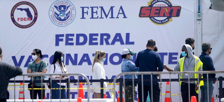 People wait in line to receive a COVID-19 vaccine at a FEMA vaccination center at Miami Dade College on April 5. With FEMA leading the federal vaccination effort in addition to the agency's more traditional disaster-response duties, employee burnout is a concern. 