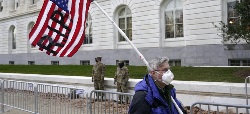 A protester walks past the Russell Senate Office Building on Capitol Hill in Washington on Friday, Jan. 8, 2021.