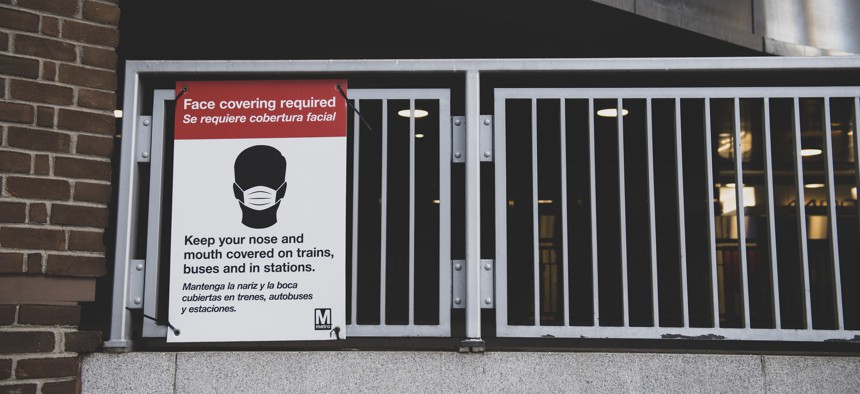 A sign outside the metro station at Mt Vernon Square 7th St-Convention Center informs riders that face coverings are required in the station and on trains.