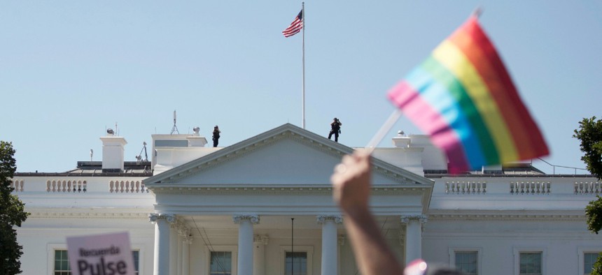 Equality March for Unity and Pride participants march past the White House in Washington in 2017. Under the Biden administration agencies are recognizing LGBTQ+ employees. 