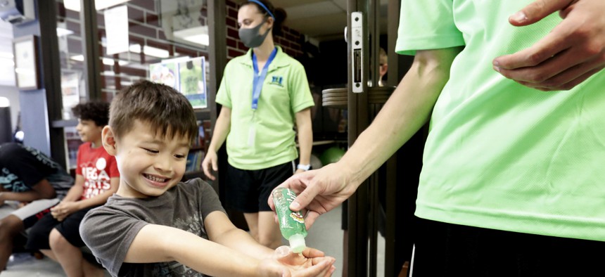 Bruce McCall, 5, smiles as he takes hand sanitizer during martial arts daycare summer camp at Legendary Blackbelt Academy in Richardson, Texas, Tuesday, May 19, 2020.