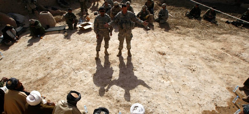 U.S. Army Lt. Col. Burton Shields, commander of the 4th Battalion, 23rd Infantry of Task Force Stryker, gestures as he talks next to his interpreter during a meeting, or shura, with village leaders in the Badula Qulp area of Afghanistan in 2010.