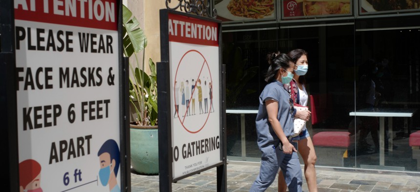 ustomers wear face masks in an outdoor mall with closed business amid the COVID-19 pandemic in Los Angeles on June 11.