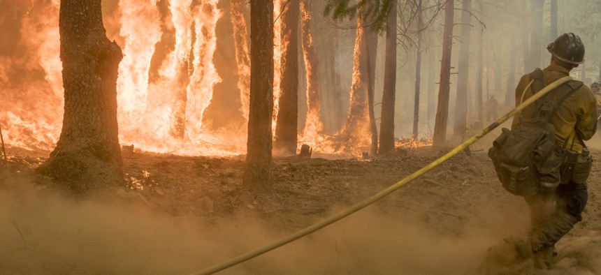 An Elk Mountain Hotshot using a hose on a 2018 California fire.