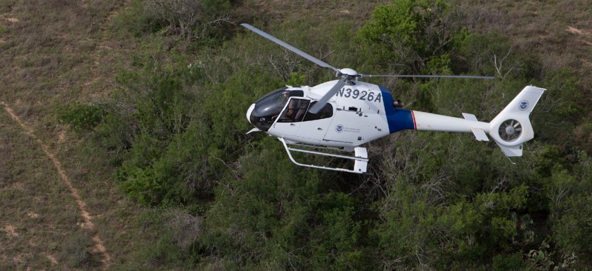 A Customs and Border Protection Air and Marine Operations agent patrols in an EC120 helicopter checking from the air for border crossers, drug smugglers and any other illegal activities along the Laredo, Texas border.