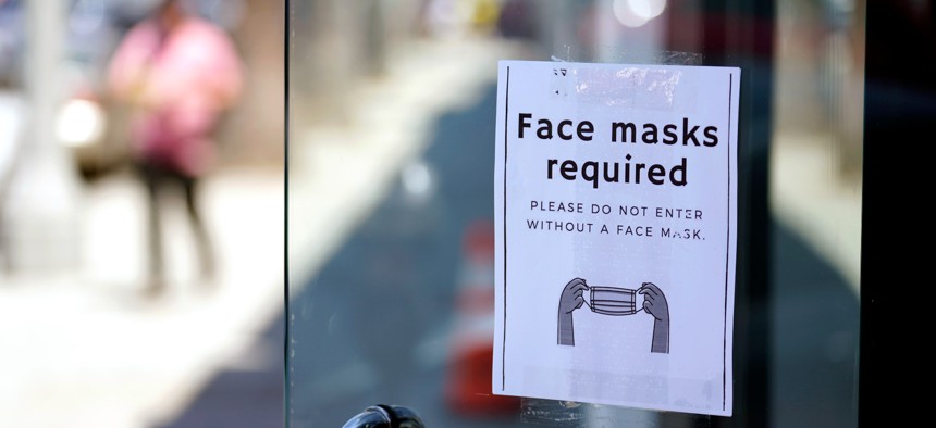 A sign advises shoppers to wear masks outside of a store Monday, July 19, 2021, in the Fairfax district of Los Angeles.